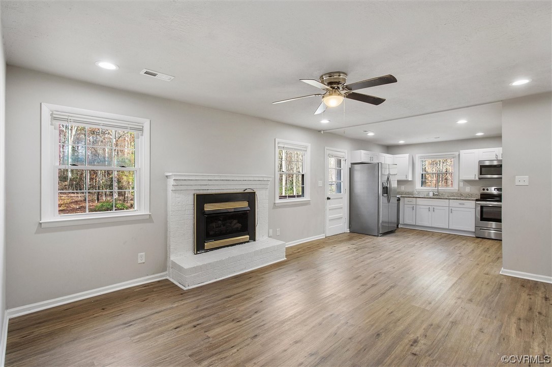 13506 Verdon Road Ruther Glen, VA 22546 - Photo 10 of 27 a view of a big room with wooden floor and a kitchen