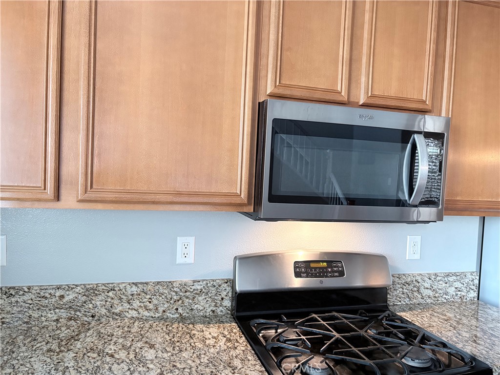 2729 Hornbeam Road Palmdale, CA 93551 - Photo 13 of 35 a kitchen with wooden cabinets and a stove top oven