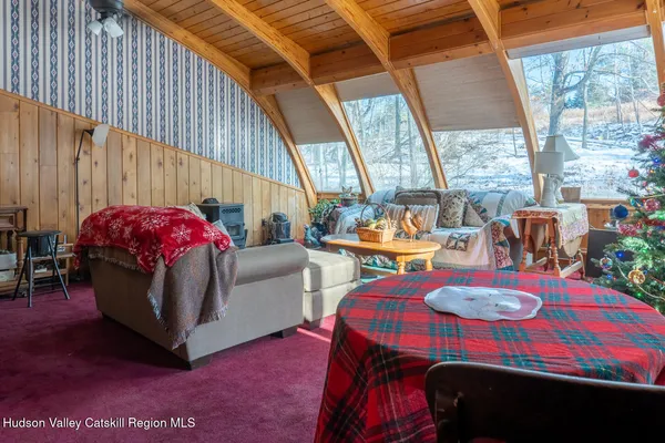 a living room with furniture a flat screen tv and a window