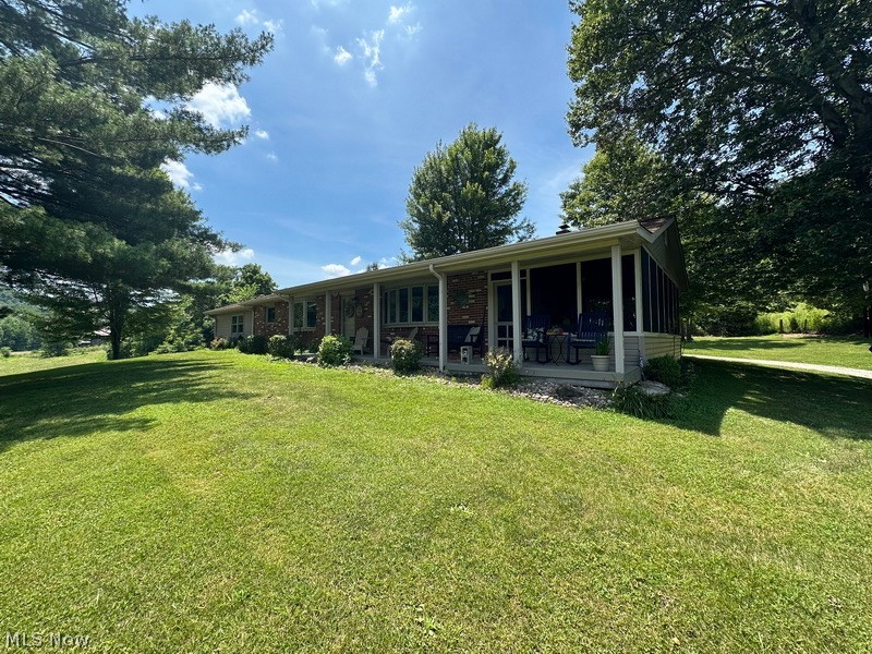 53310 Mud Run Road Senecaville, OH 43780 - Photo 26 of 28 Front of house with a yard, brick siding, and a wooden porch