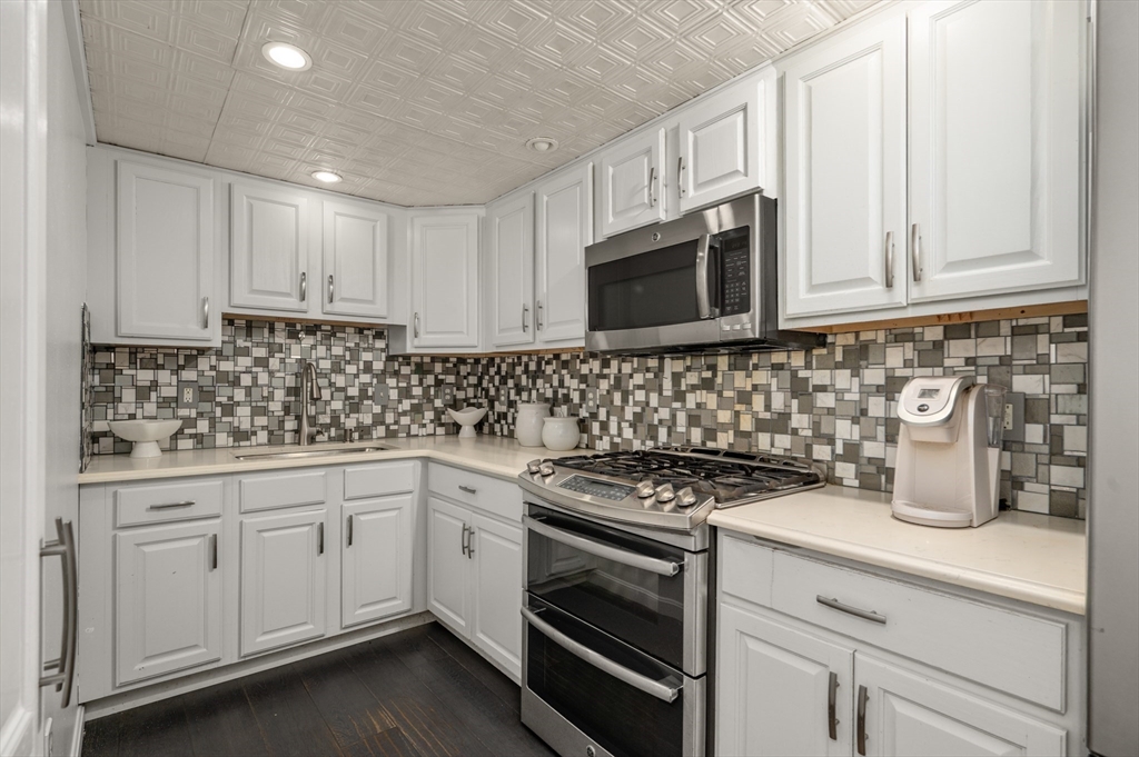 16 Autumn Woods Road Salem, NH 03079 - Photo 24 of 29 a kitchen with granite countertop white cabinets and stainless steel appliances
