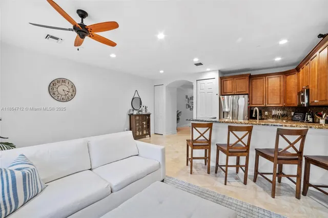 a living room with furniture kitchen view and a window