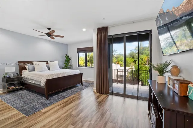 a bedroom with a bed a flat screen tv and a large window with the outer view