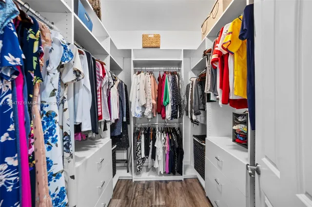 a view of walk in closet with clothes and shoes