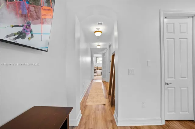 a view of a hallway with wooden floor and glass door