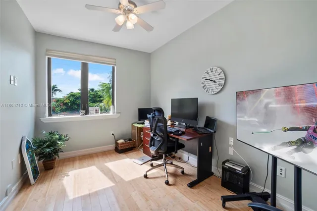 a view of a workspace with furniture and a window