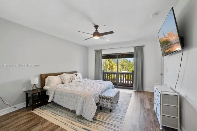 a bedroom with a bed and a flat tv screen on dresser