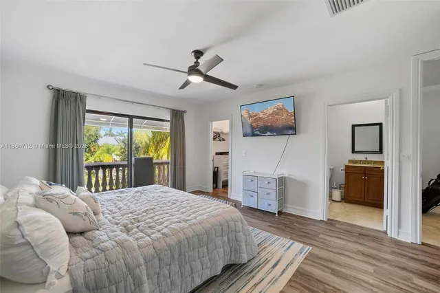 a bedroom with a large bed a chandelier and dresser