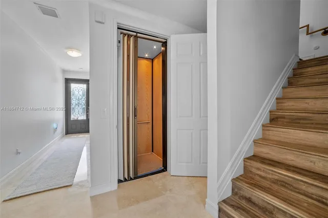 a view of a hallway with wooden floor and entryway