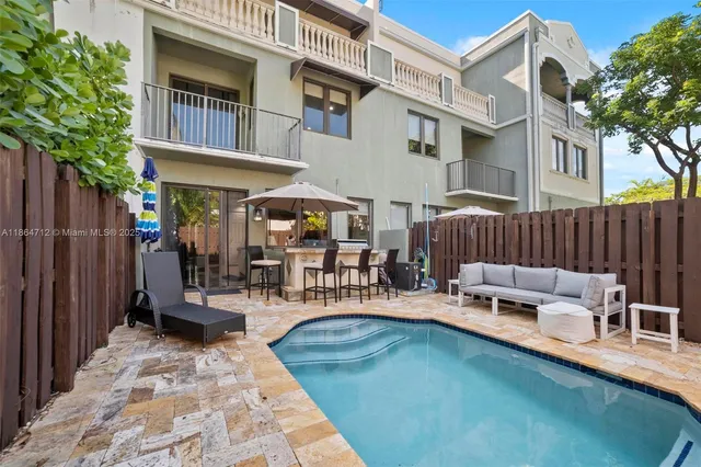 a view of a swimming pool with a patio and a yard