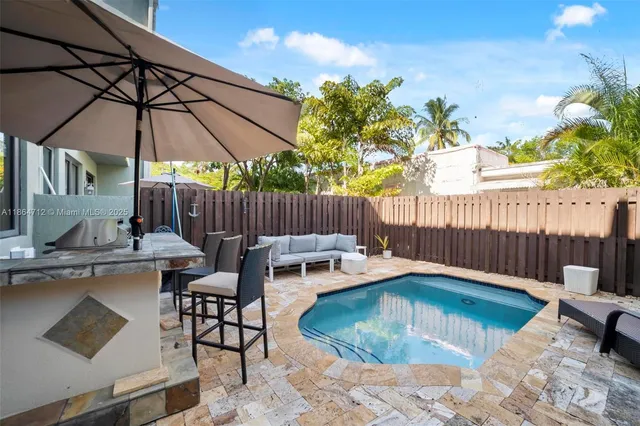 a view of backyard with swimming pool and furniture
