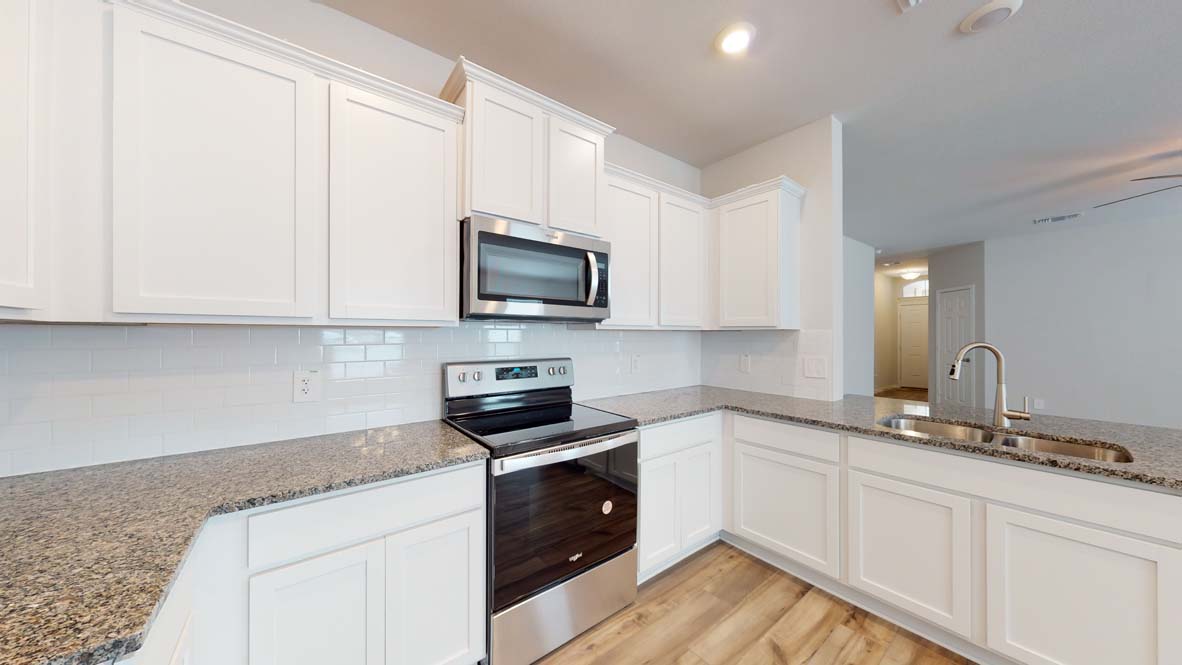 300 Creekfall Road Burnet, TX 78611 - Photo 6 of 23 a kitchen with granite countertop white cabinets sink and stainless steel appliances