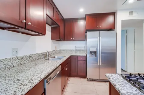 a kitchen with granite countertop stainless steel appliances and wooden cabinets
