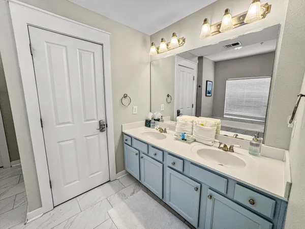 a spacious bathroom with a double vanity sink and mirror