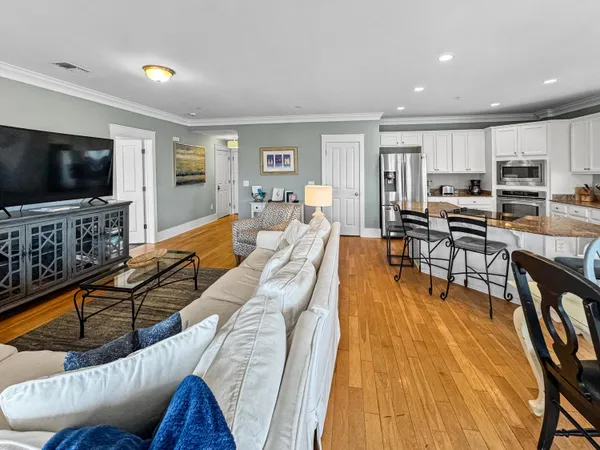 a living room with stainless steel appliances furniture and a flat screen tv
