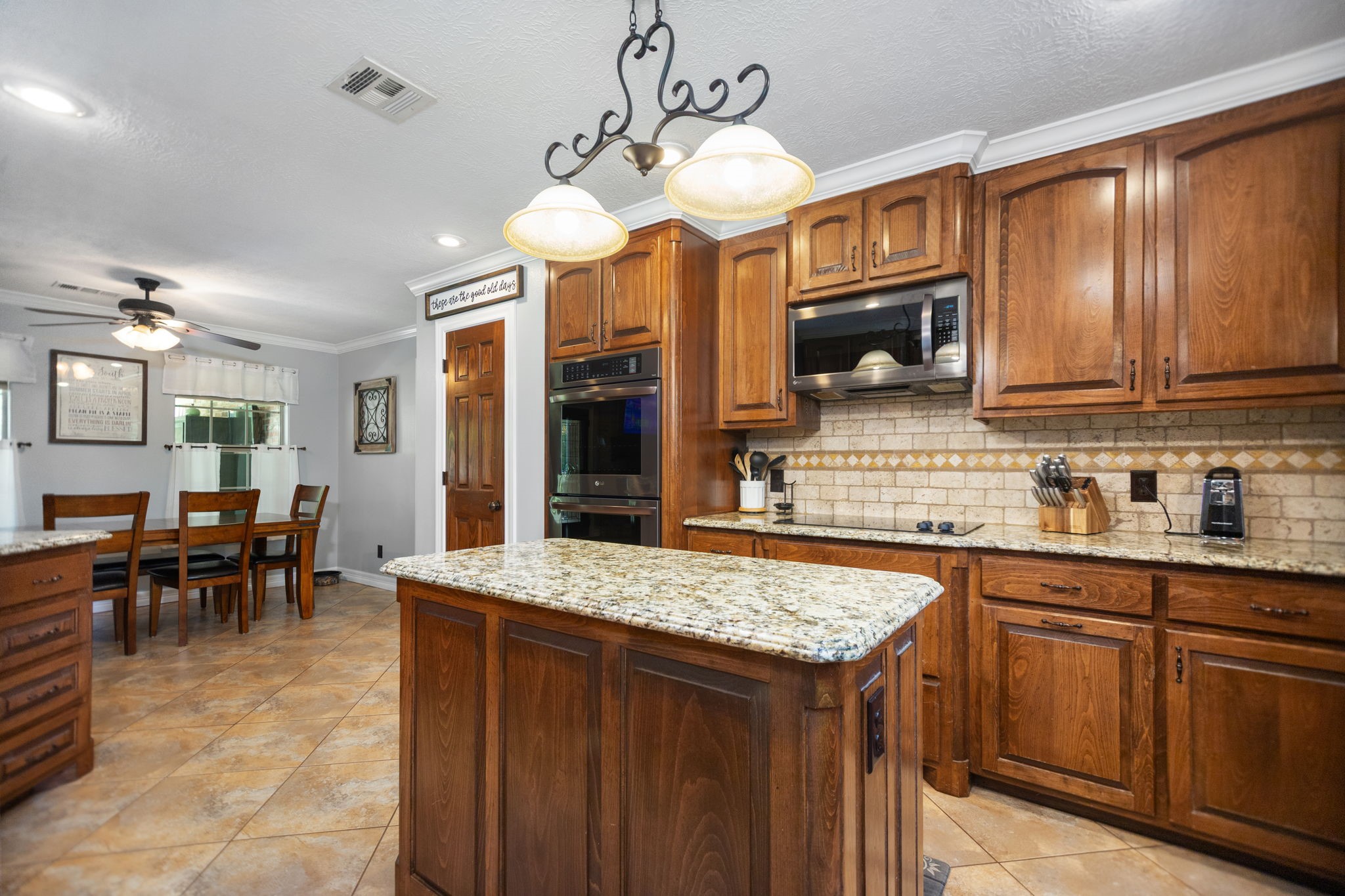4145 Fm 770 Road Kountze, TX 77625 - Photo 20 of 38 a kitchen with stainless steel appliances granite countertop wooden cabinets a stove top oven a sink a dining table and chairs