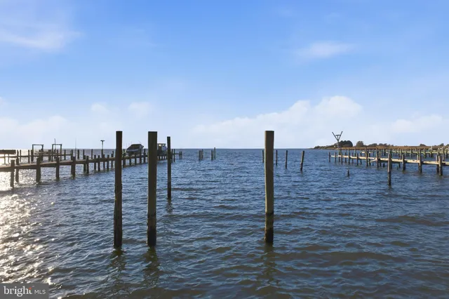 an aerial view of ocean and residential houses with outdoor space
