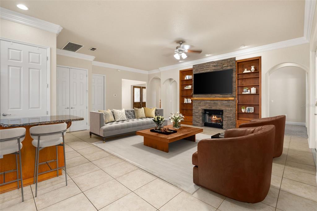 3950 Southeast 39th Circle Ocala, FL 34480 - Photo 12 of 40 a living room with furniture a fireplace and a flat screen tv