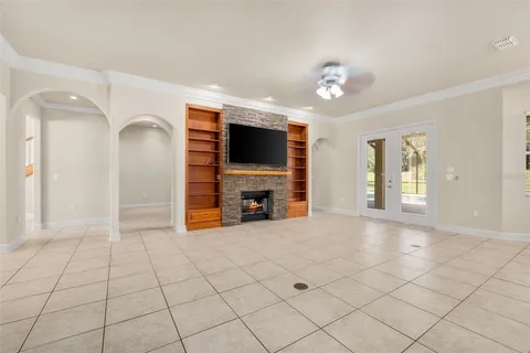 a view of an empty room with a fireplace and a window
