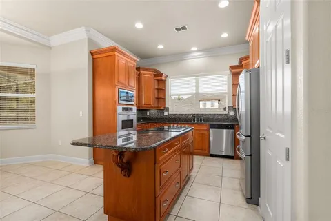 a kitchen with stainless steel appliances granite countertop a sink and a refrigerator