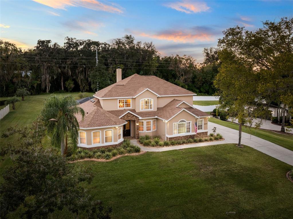 3950 Southeast 39th Circle Ocala, FL 34480 - Photo 2 of 40 a view of a white house with a big yard and large trees