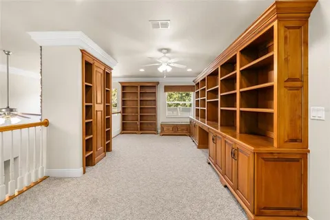 an empty room with a ceiling fan and a fan