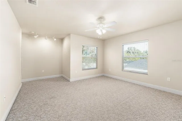 a view of an empty room with a ceiling fan