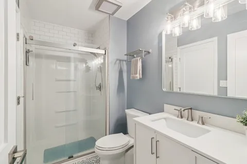 a bathroom with a sink toilet vanity and shower