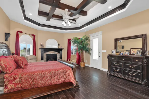 a bedroom with a bed dresser and a fireplace