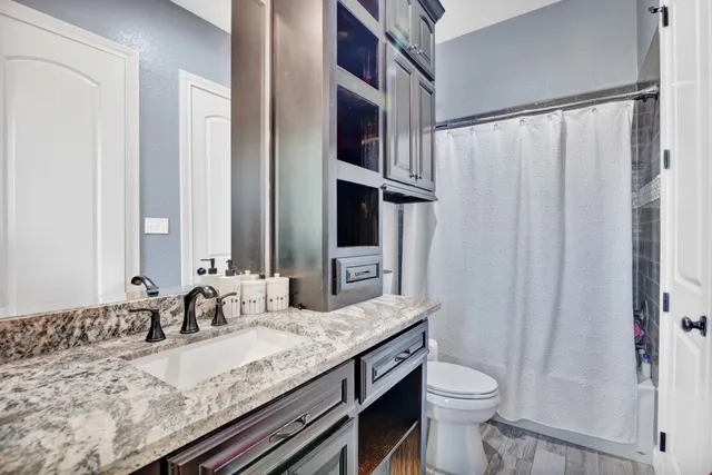a bathroom with a granite countertop sink and a mirror