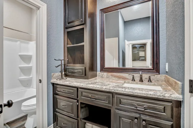 a bathroom with a granite countertop sink and a mirror