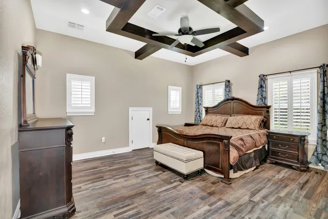 a bedroom with a bed ceiling fan and a window