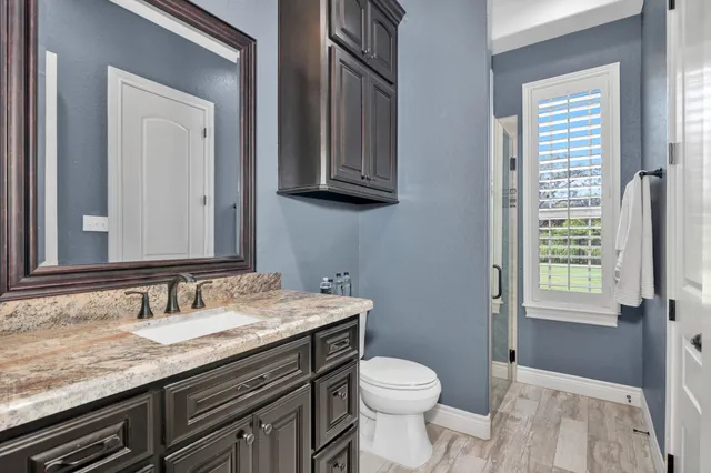 a bathroom with a granite countertop sink toilet and shower