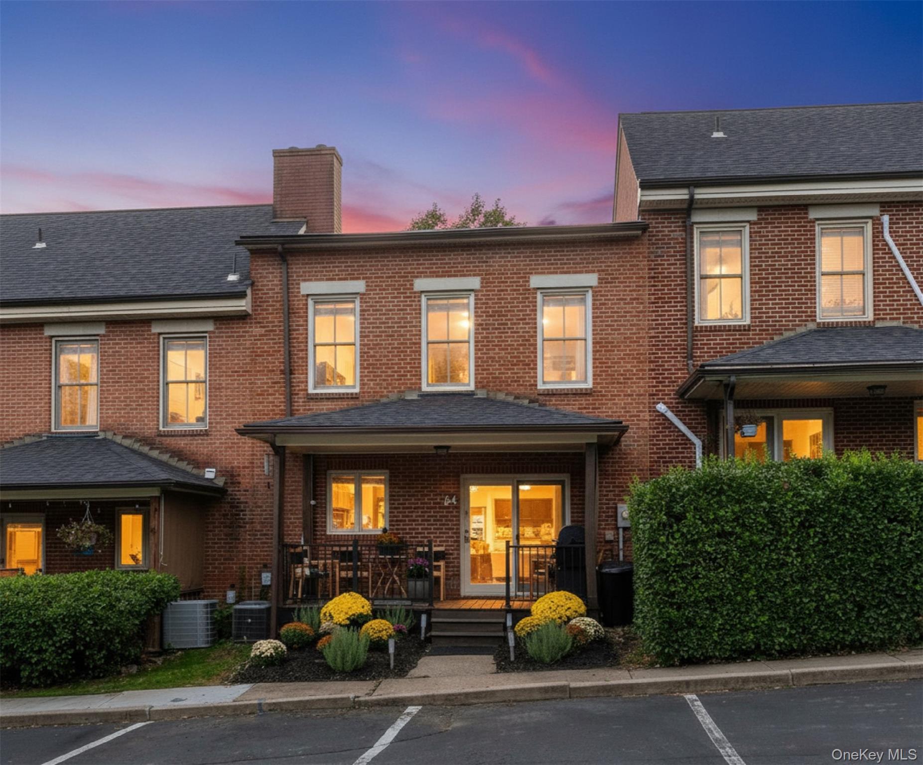a front view of a building with lots of trees and plants