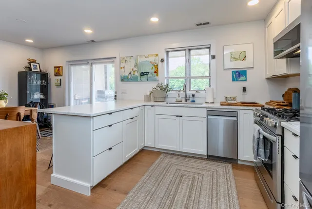 a kitchen with stainless steel appliances a sink stove and cabinets