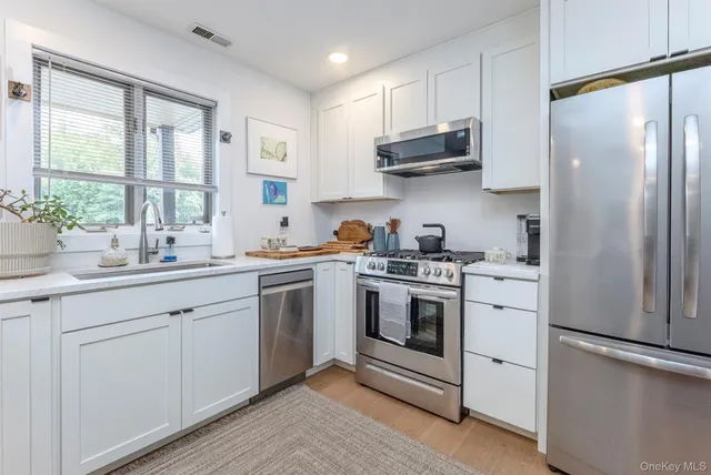 a kitchen with stainless steel appliances white cabinets and a sink