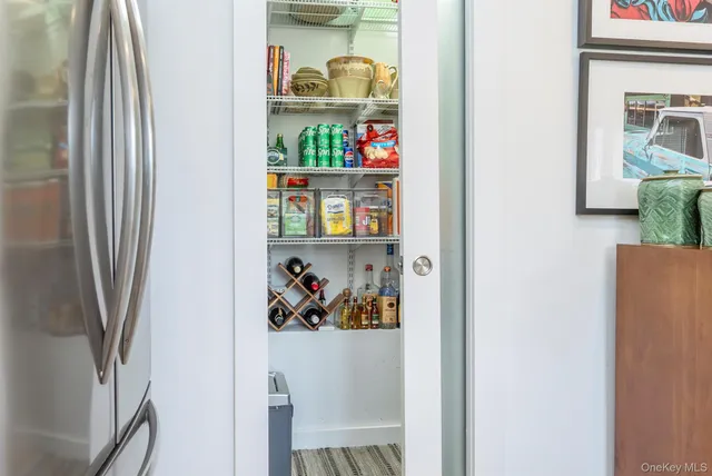 a view of a hallway with painting on the wall and a window