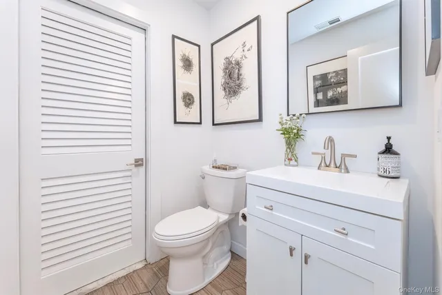 a bathroom with a toilet a sink and mirror