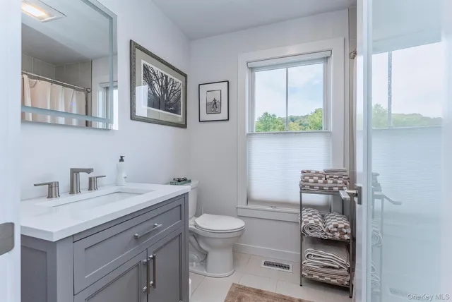 a bathroom with a toilet a sink and a window