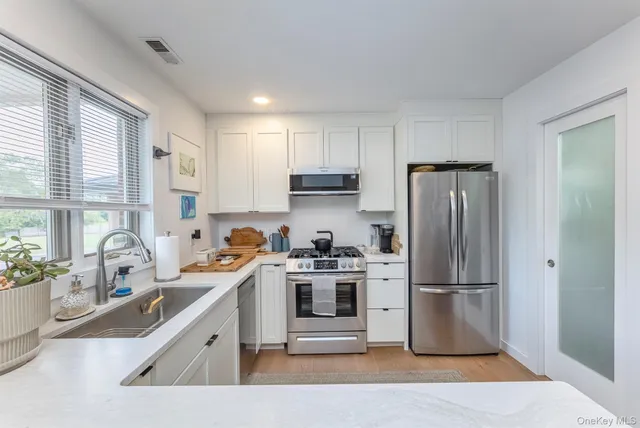 a kitchen with a refrigerator a stove a sink and a cabinets