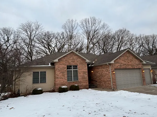 a front view of a house with a yard covered in snow