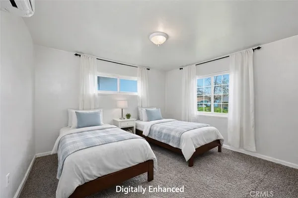 a bedroom with two beds and a window