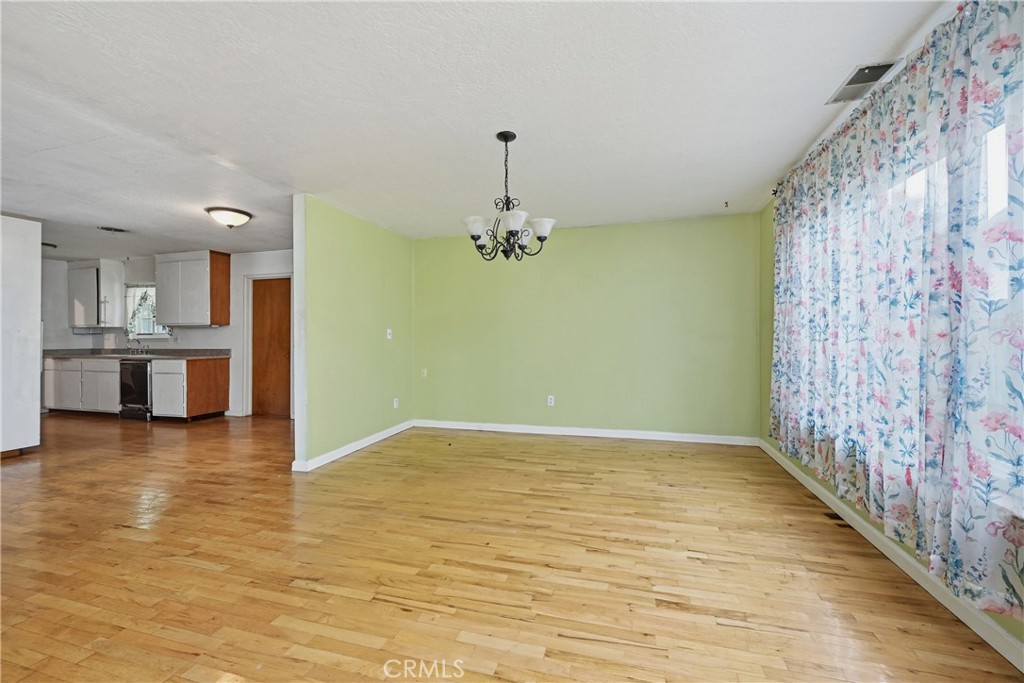 15050 Lakeview Way Clearlake, CA 95422 - Photo 9 of 24 a view of empty room with wooden floor and kitchen