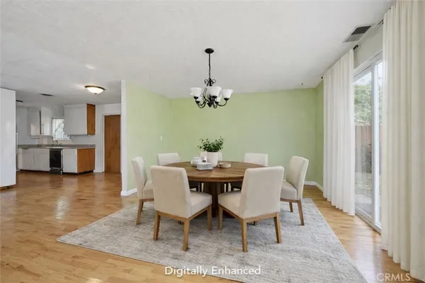 a dining room with furniture wooden floor a chandelier and a rug