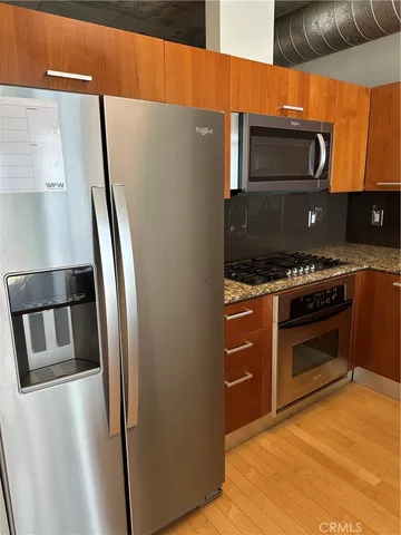 a kitchen with stainless steel appliances a refrigerator a stove and a sink