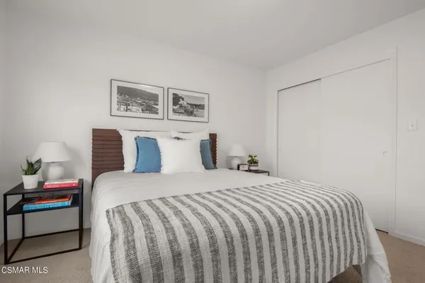 a bedroom with a bed and a painting on the wall