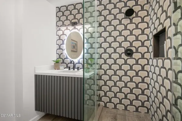 a view of a white house with large windows and a tree