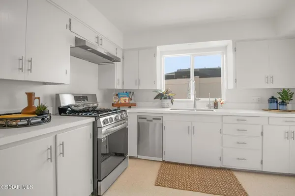 a kitchen with granite countertop white cabinets and white appliances