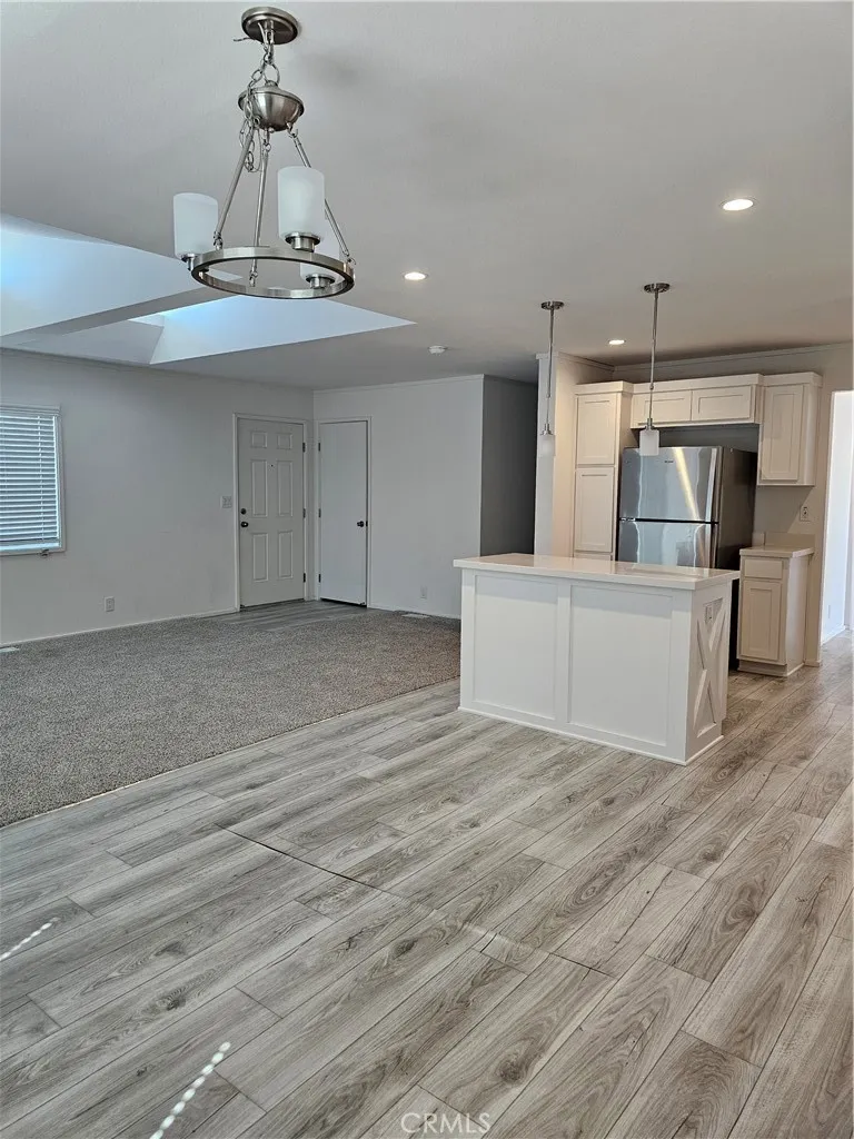 1560 Massachusetts Avenue, Unit 94 Riverside, CA 92507 - Photo 13 of 15 a view of a hallway with wooden floor and chandelier