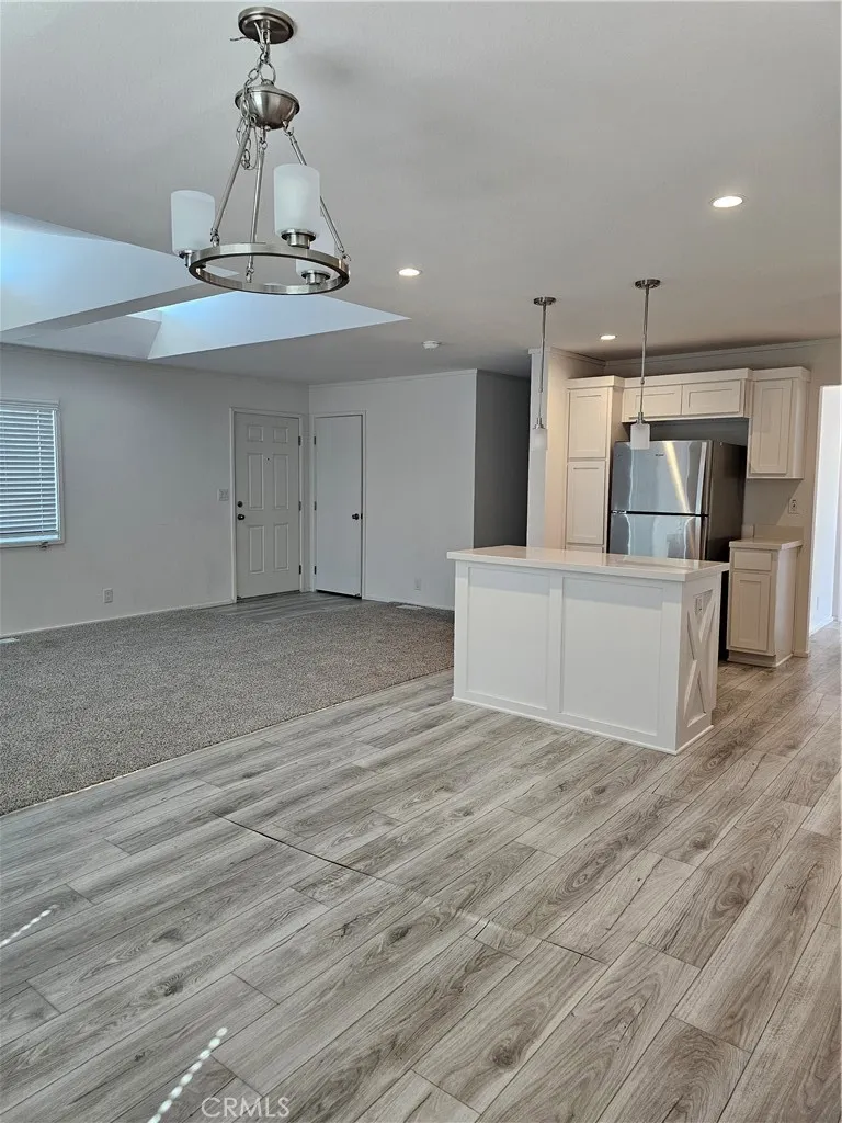 1560 Massachusetts Avenue, Unit 94 Riverside, CA 92507 - Photo 8 of 15 a view of a hallway with wooden floor and chandelier